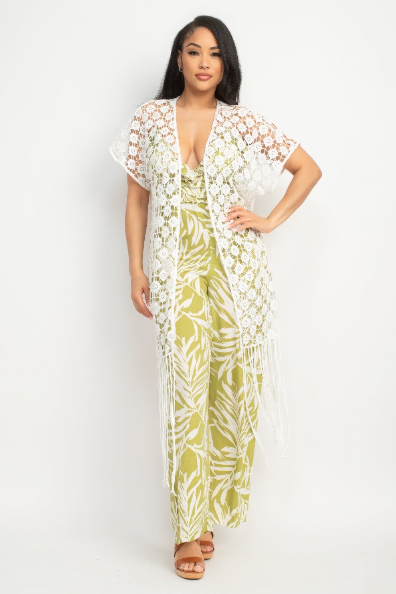 Woman wearing a floral jumpsuit with a matching cover-up on a white background