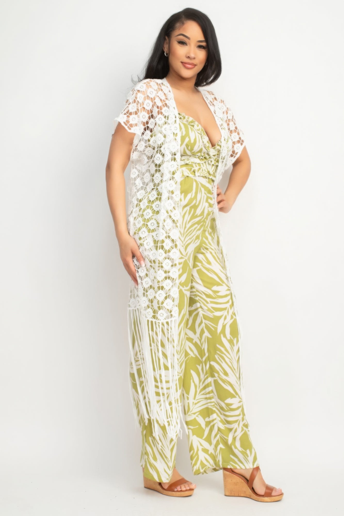Woman wearing a green and white floral jumpsuit with a matching cover-up on a white background