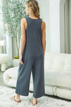 Woman wearing a blue jumpsuit in a living room setting