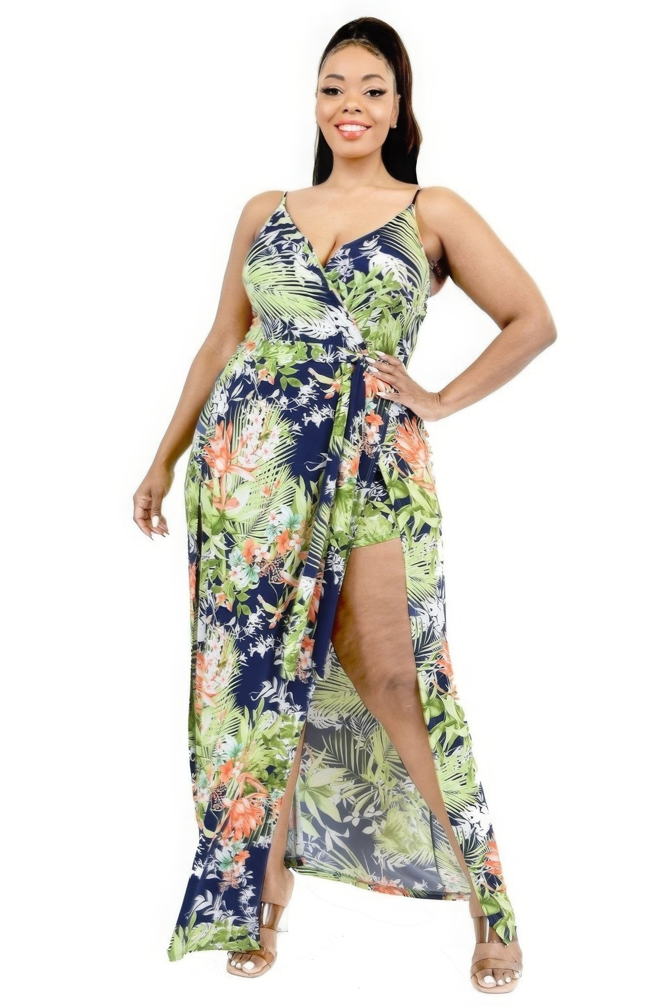 Woman wearing a colorful floral dress with a slit on a white background