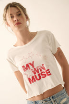 Woman wearing a white t-shirt with 'My Own Muse' text and star designs.