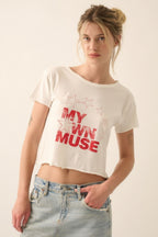 Woman wearing a white t-shirt with 'My Own Muse' text and red stars on a plain background