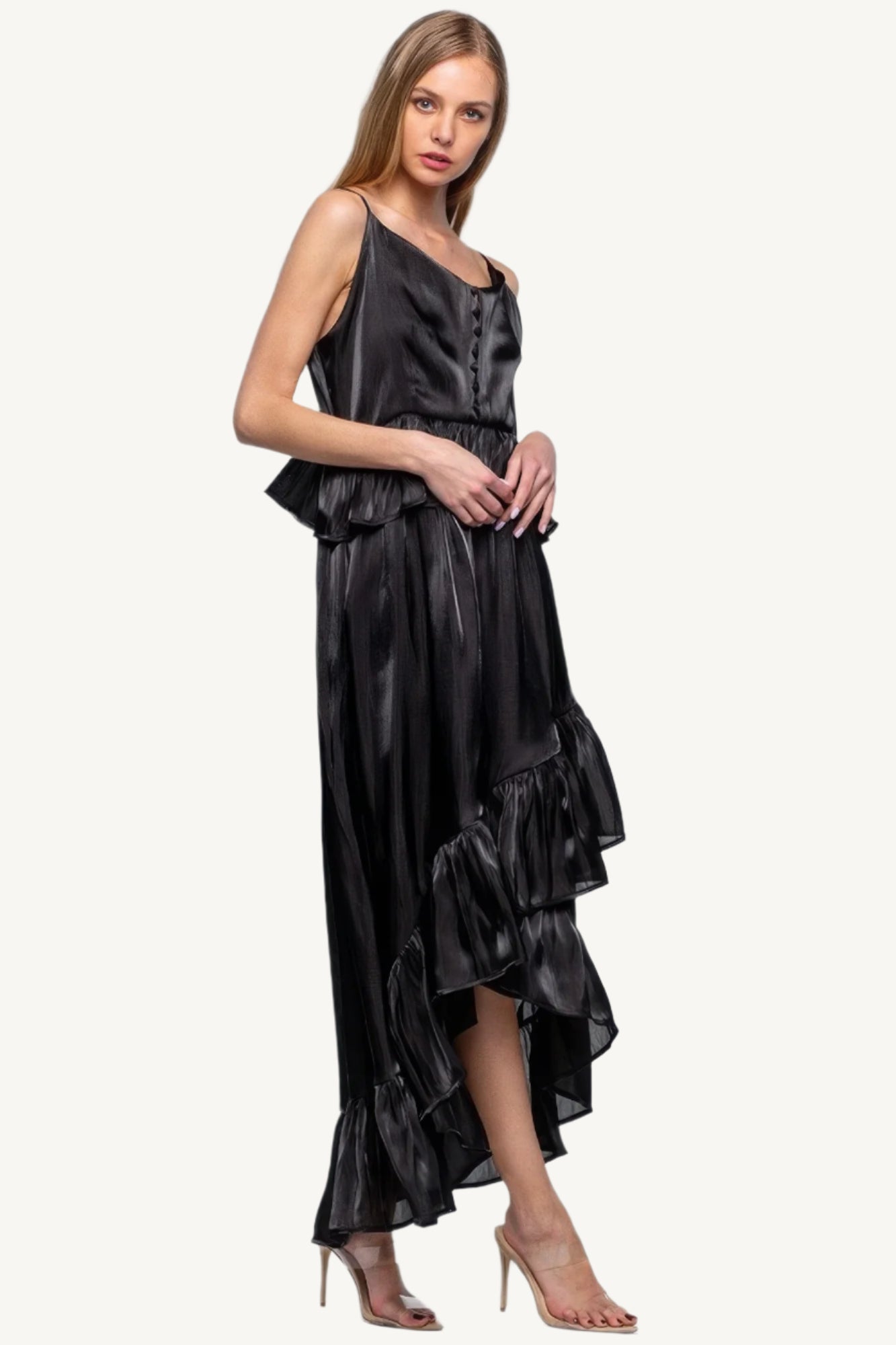 Sleeveless ruffle dress with adjustable straps and asymmetric hem, crafted from 100% polyester for a flowing, elegant silhouette with a soft shimmer.