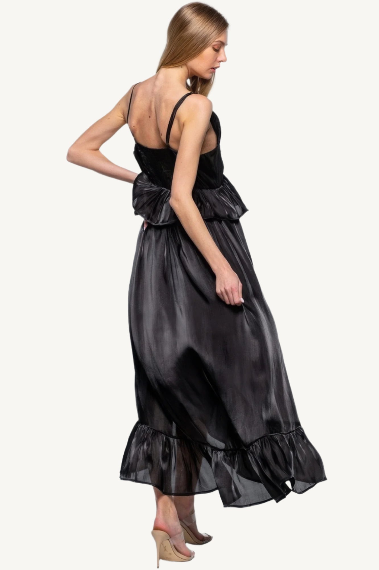 Sleeveless ruffle dress with adjustable straps and asymmetric hem, crafted from 100% polyester for a flowing, elegant silhouette with a soft shimmer.