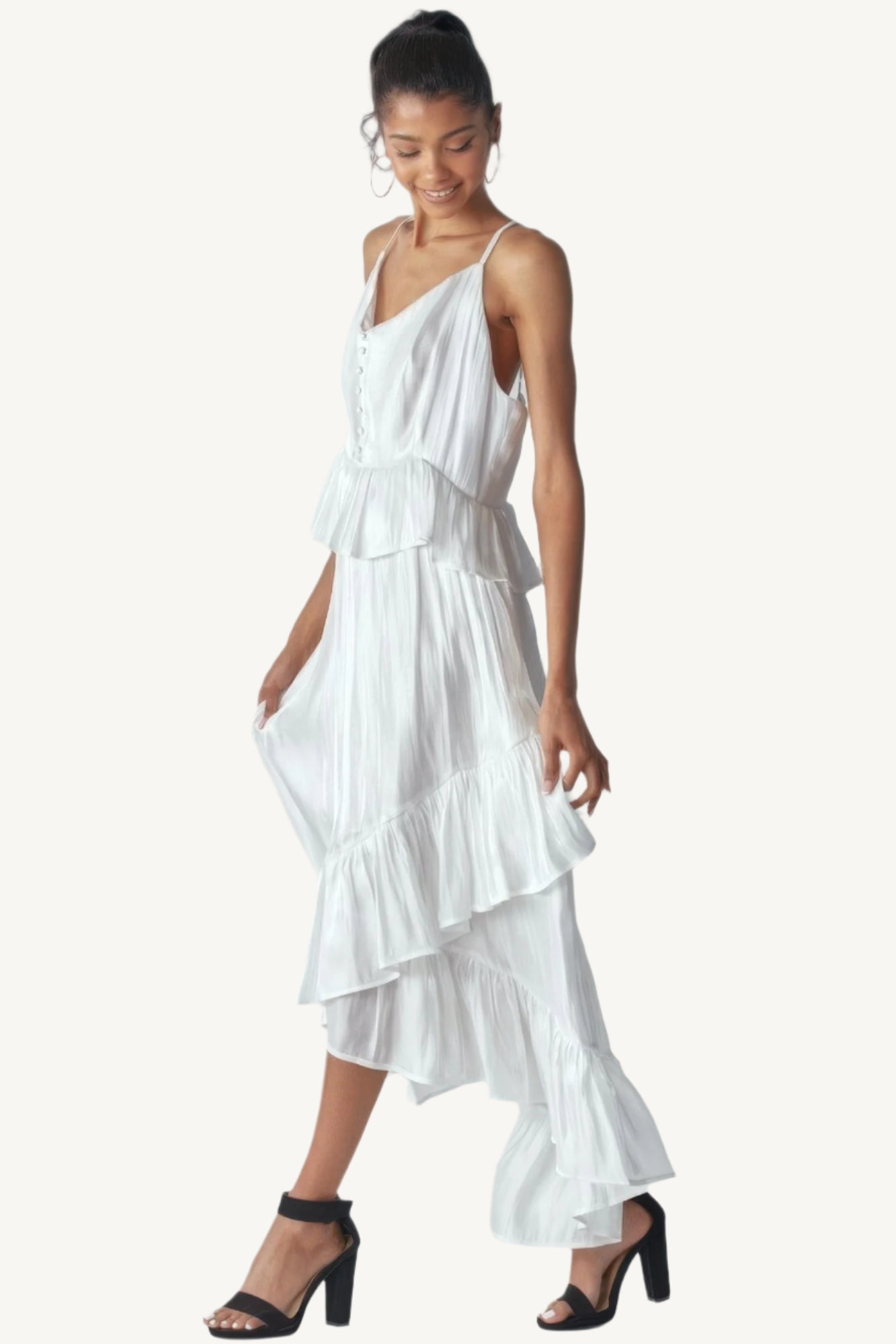 Shimmering sleeveless ruffle dress with adjustable straps, asymmetric hemline, and delicate ruffle details. Designed to dazzle with elegance and flow.