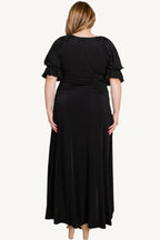 Plus-size solid color faux wrap maxi dress with Venezia fabric finish. Elegant silhouette offering style, comfort, and versatility for all occasions.