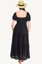 Plus-size black tiered maxi dress with front tie, puff sleeves, and flowing silhouette. Lightweight polyester fabric for breathable, elegant comfort and style.