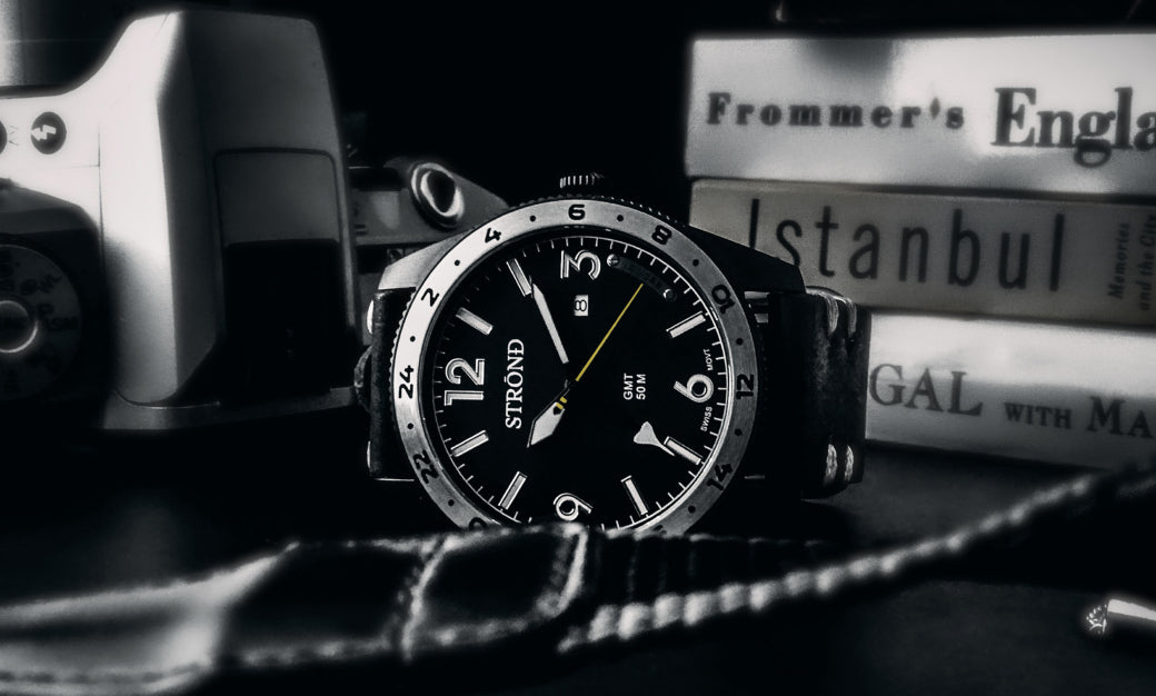 Stuhrling watch on a textured surface with books in the background