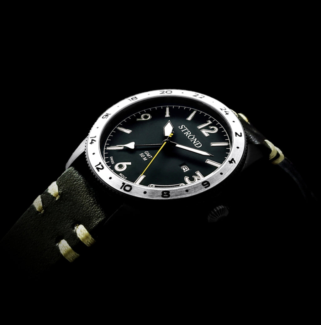 Black wristwatch with a detailed face on a black background