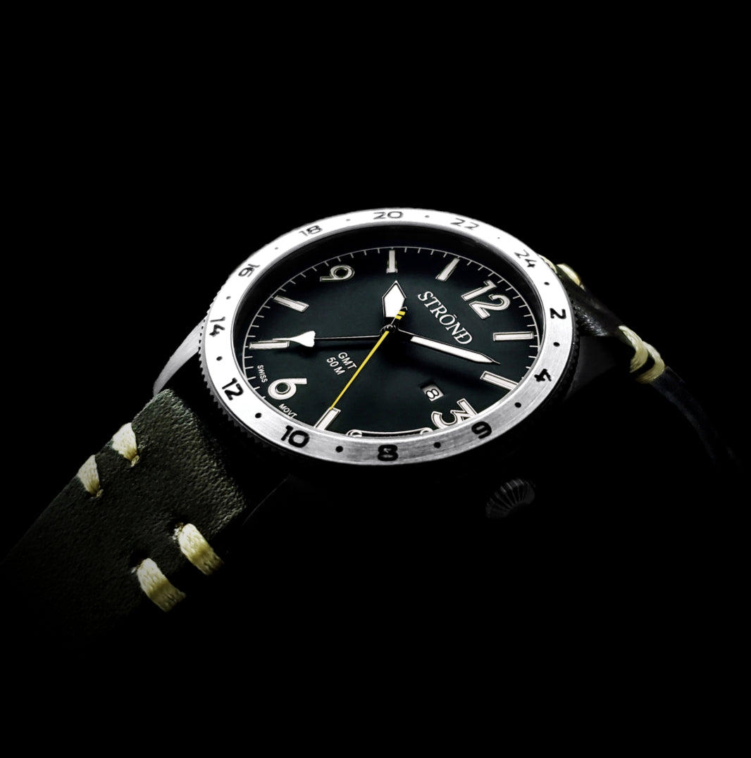Black wristwatch with a detailed face on a black background