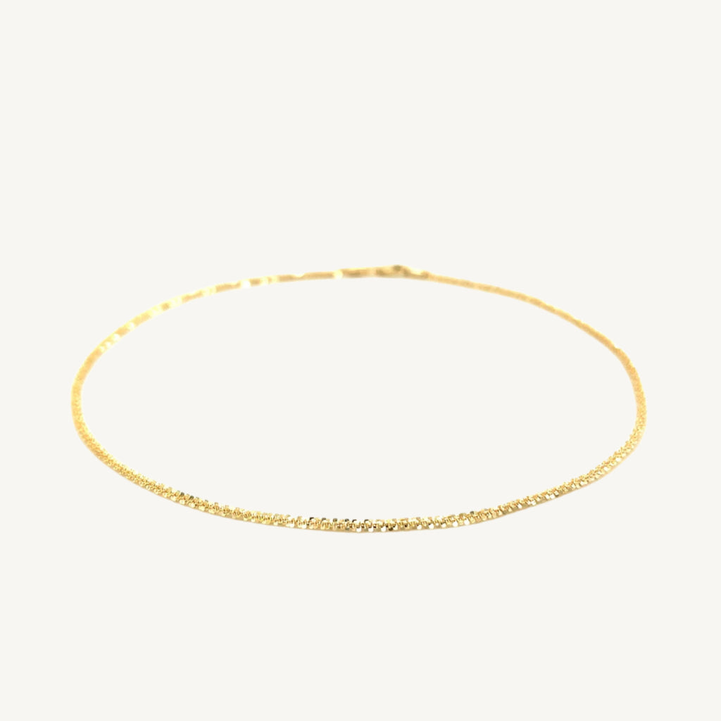 "Delicate 10k yellow gold sparkle anklet, 1.5 mm wide, with a shimmering finish that catches the light beautifully."