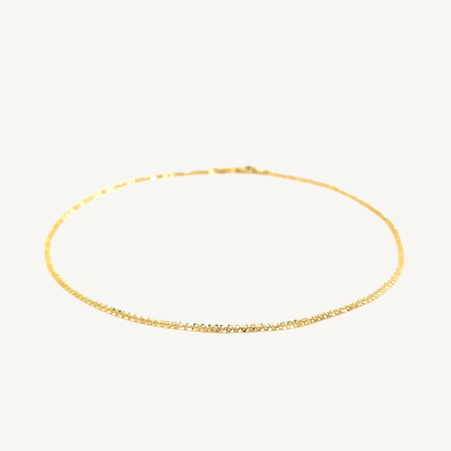 "Delicate 10k yellow gold sparkle anklet, 1.5 mm wide, with a shimmering finish that catches the light beautifully."