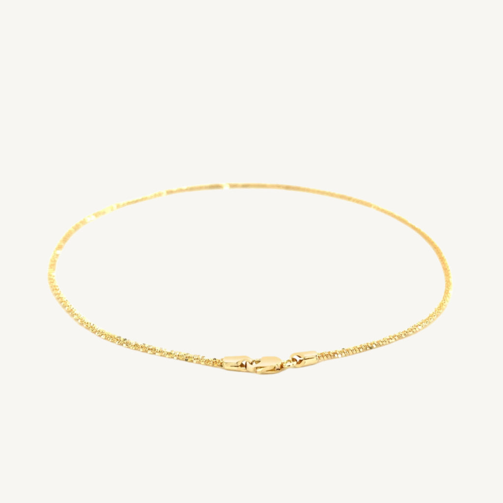 "Delicate 10k yellow gold sparkle anklet, 1.5 mm wide, with a shimmering finish that catches the light beautifully."