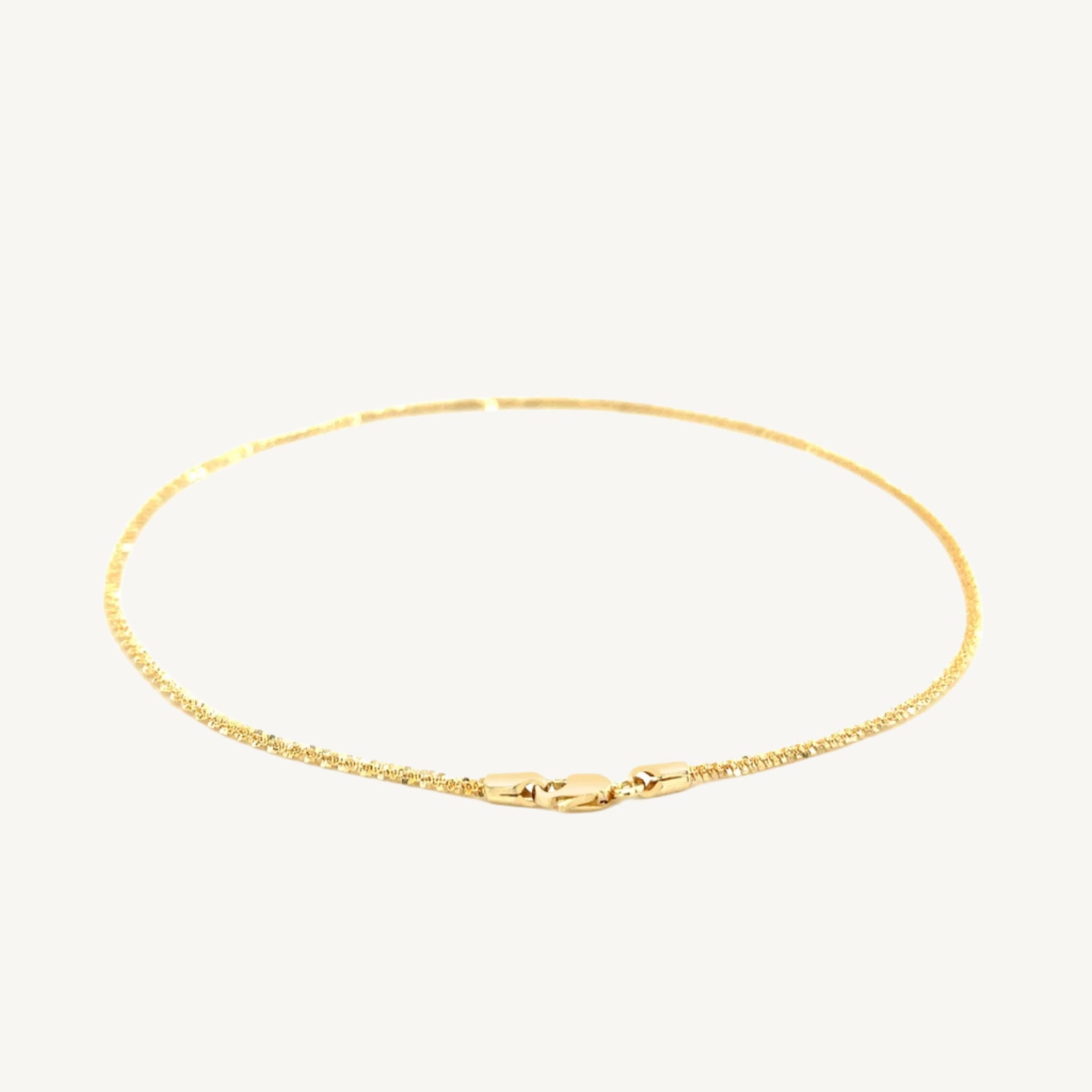 "Delicate 10k yellow gold sparkle anklet, 1.5 mm wide, with a shimmering finish that catches the light beautifully."