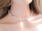 Necklace with small stones worn by a person, focusing on the necklace.
