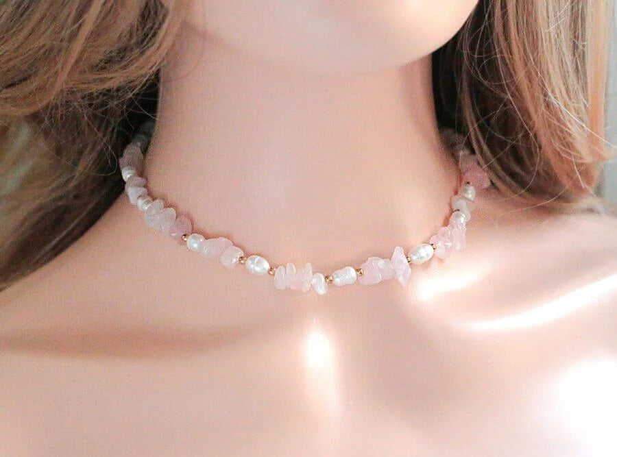 Necklace with small stones worn by a person, focusing on the necklace.