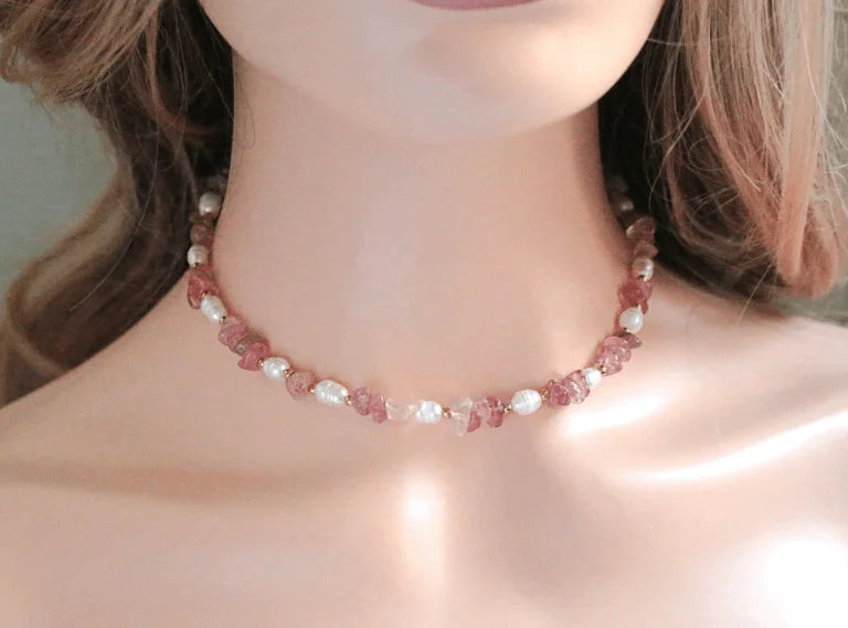 Necklace with pink and white beads worn by a person