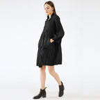 Woman wearing a black dress with long sleeves on a white background