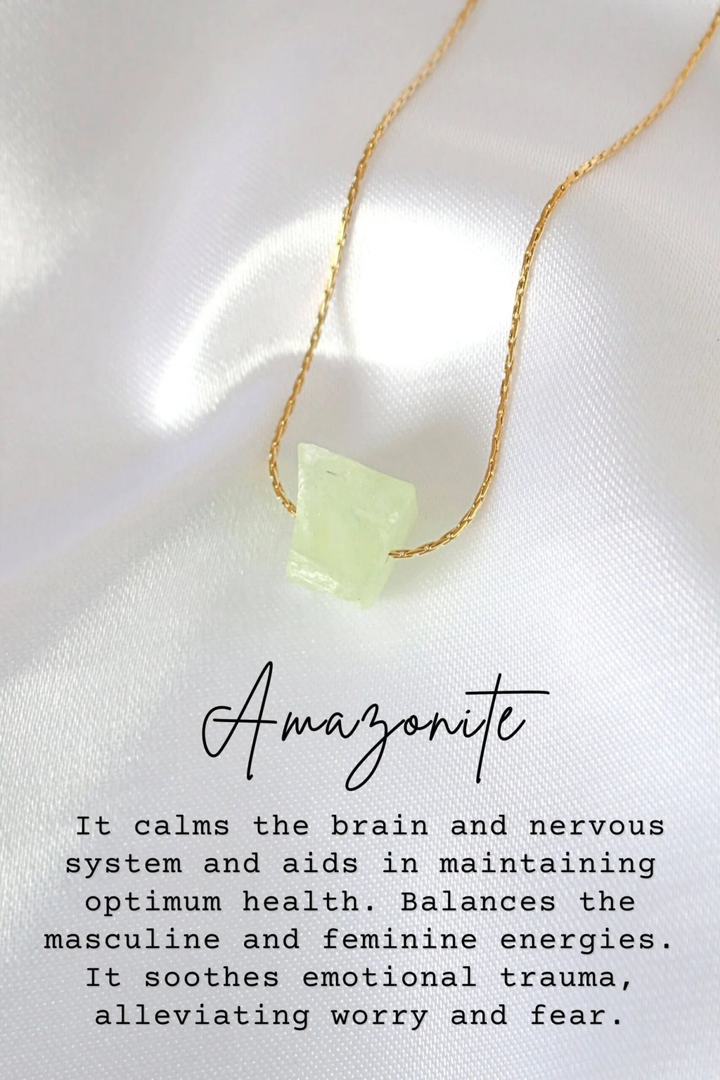 Necklace with a green stone pendant on a white fabric background