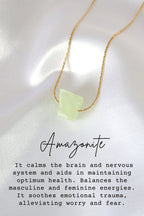 Necklace with a green stone pendant on a white fabric background
