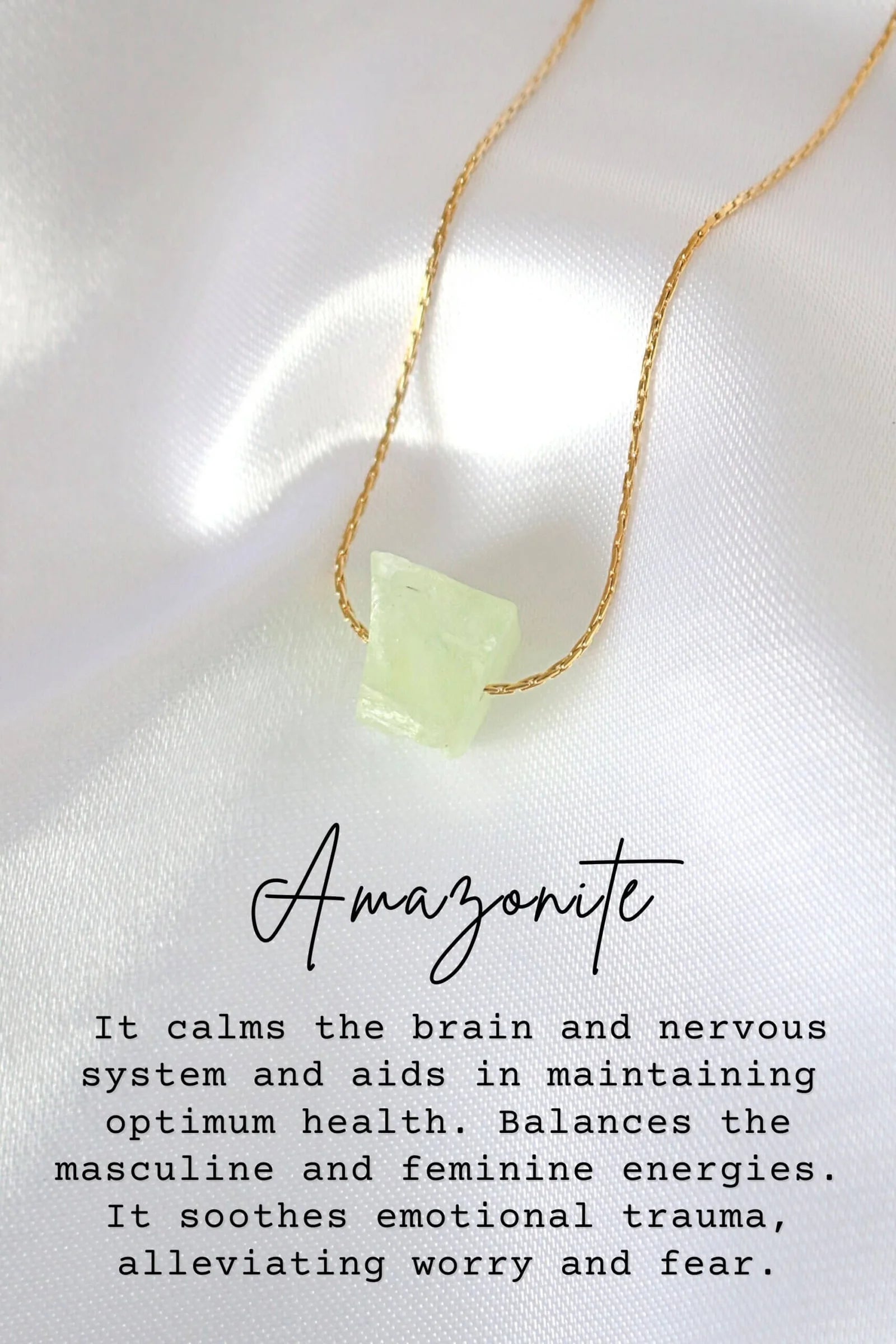 Necklace with a green stone pendant on a white fabric background