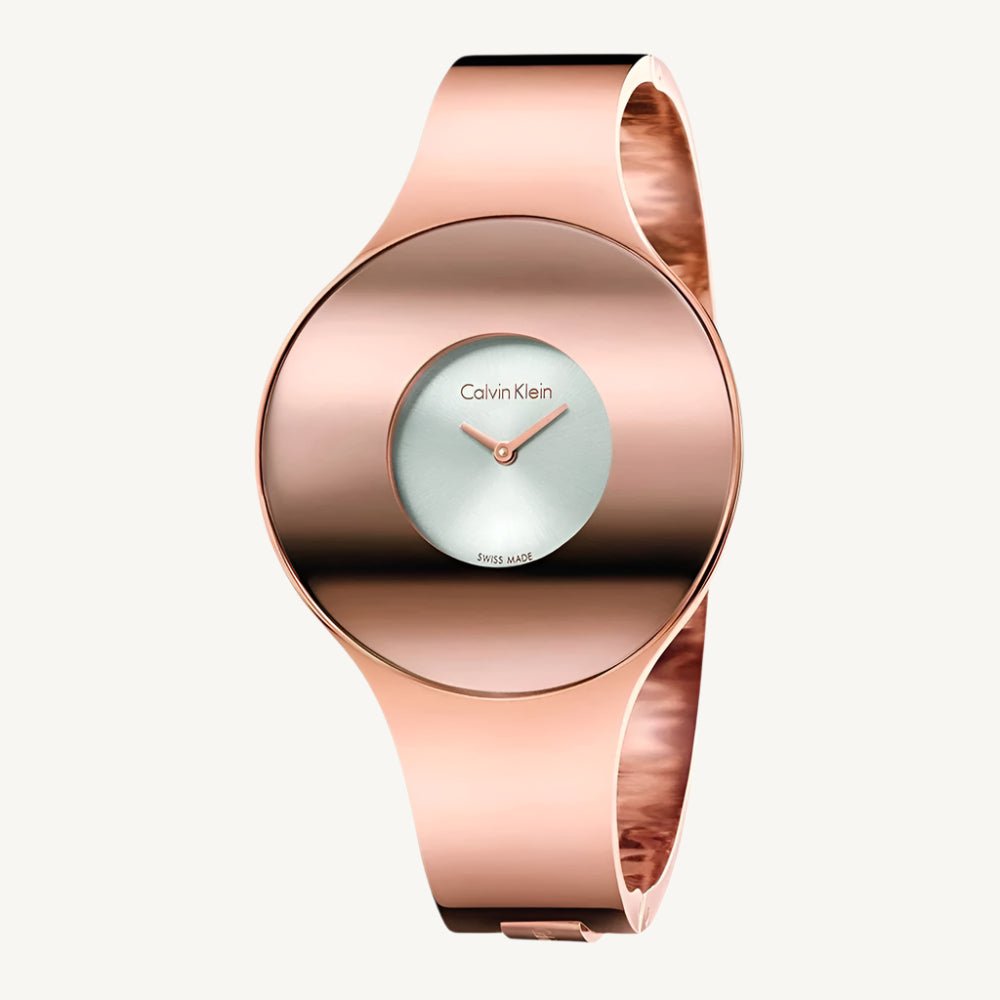 Elegant rose gold-tone ladies’ watch from Calvin Klein with polished stainless steel case and strap, silver dial, quartz movement, and 3 bar water resistance.