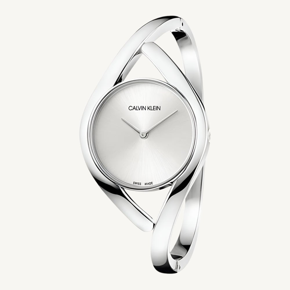 Stylish ladies’ silver-tone watch by Calvin Klein with a polished stainless steel case and strap, silver dial, slim profile, and quartz movement with 3 bar water resistance.