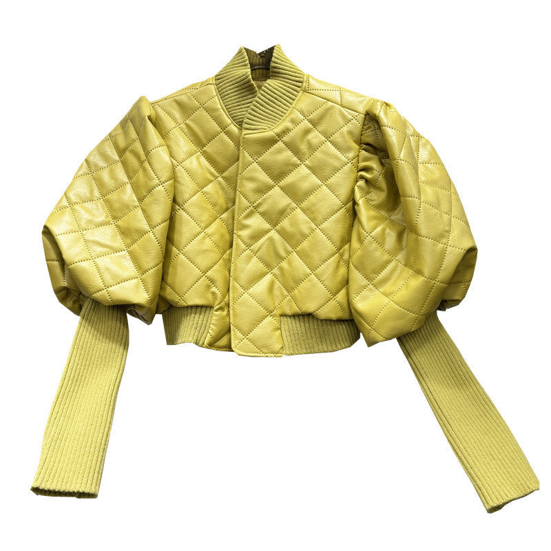 Yellow quilted jacket with ribbed sleeves on a white background