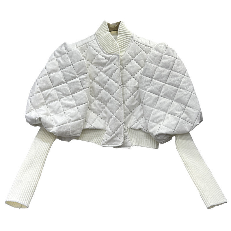White quilted shrug over a white sweater on a white background