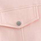 Close-up of a pink fabric with a button on a light pink background