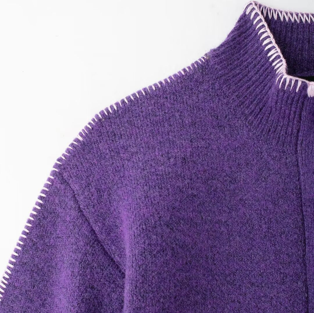 Close-up of a purple sweater with a white collar on a white background