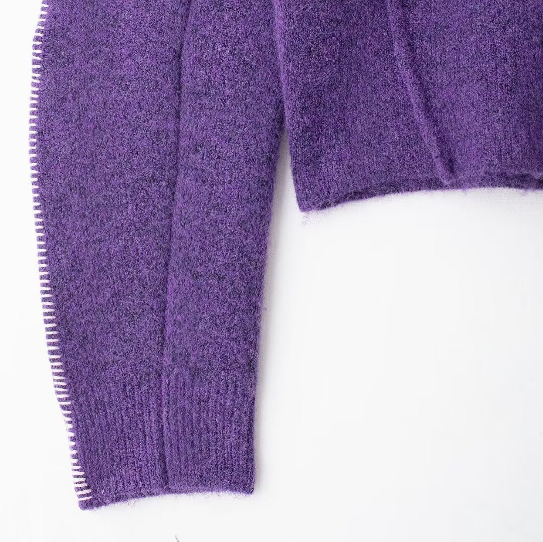Close-up of a purple textured sweater sleeve on a white background