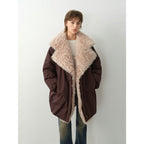 Person wearing a brown coat with a fur collar on a white background