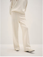 White pants worn by a person on a white background