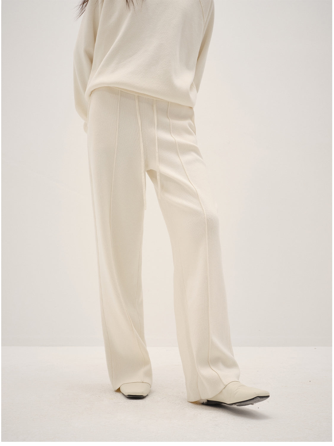 White pants worn by a person on a white background