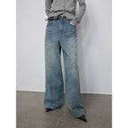 Person wearing wide-leg jeans with a plain background