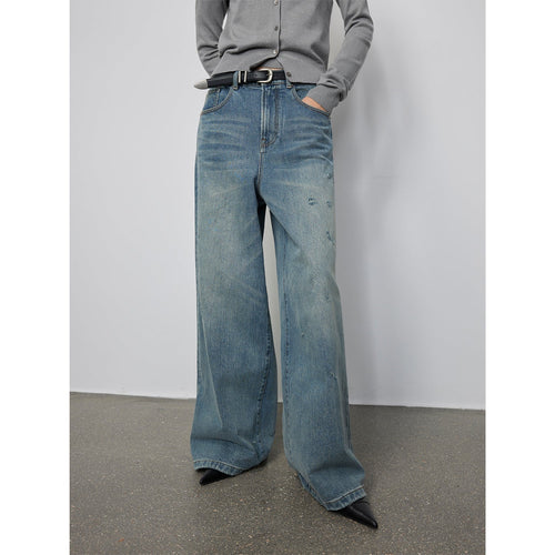 Person wearing wide-leg jeans with a plain background