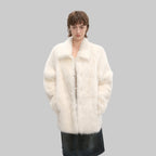 Person wearing a white fur coat against a white background