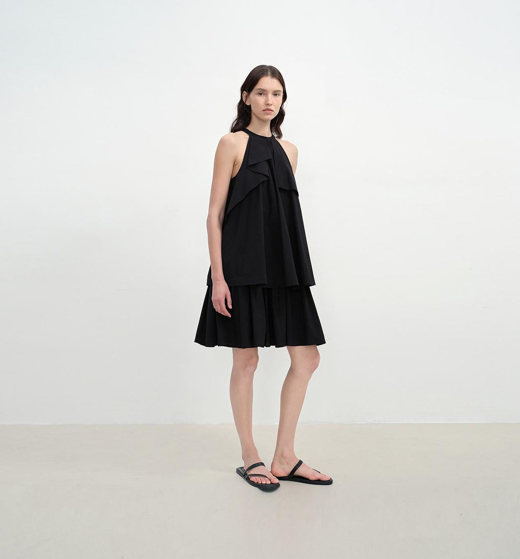 Woman wearing a black dress against a white background