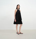 Woman wearing a black dress against a white background