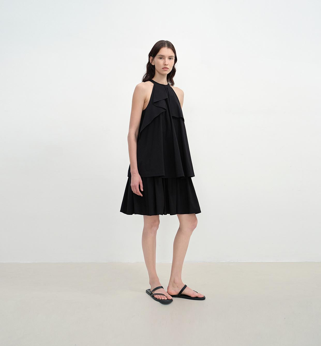 Woman wearing a black dress against a white background