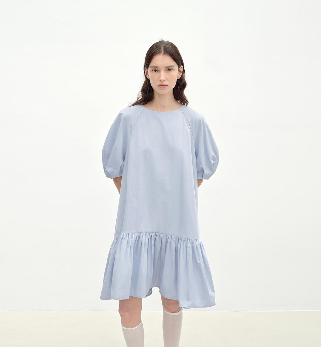 Woman wearing a light blue dress on a white background