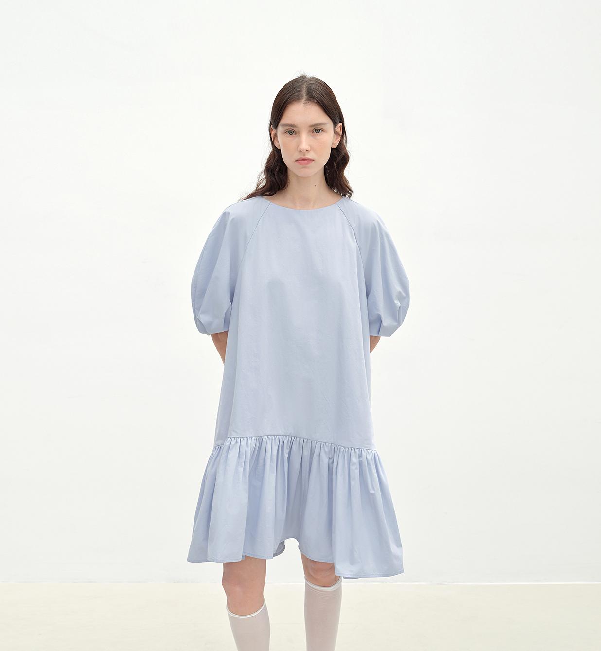 Woman wearing a light blue dress on a white background