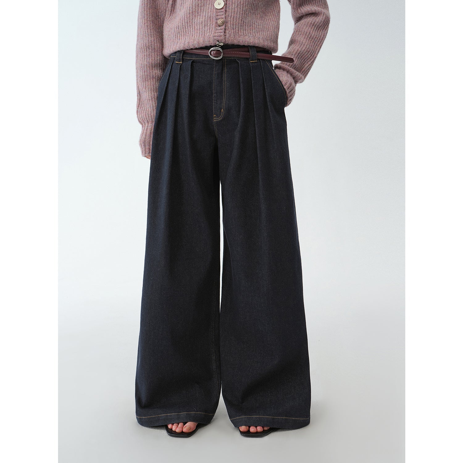 Person wearing black wide-leg pants with a plain background