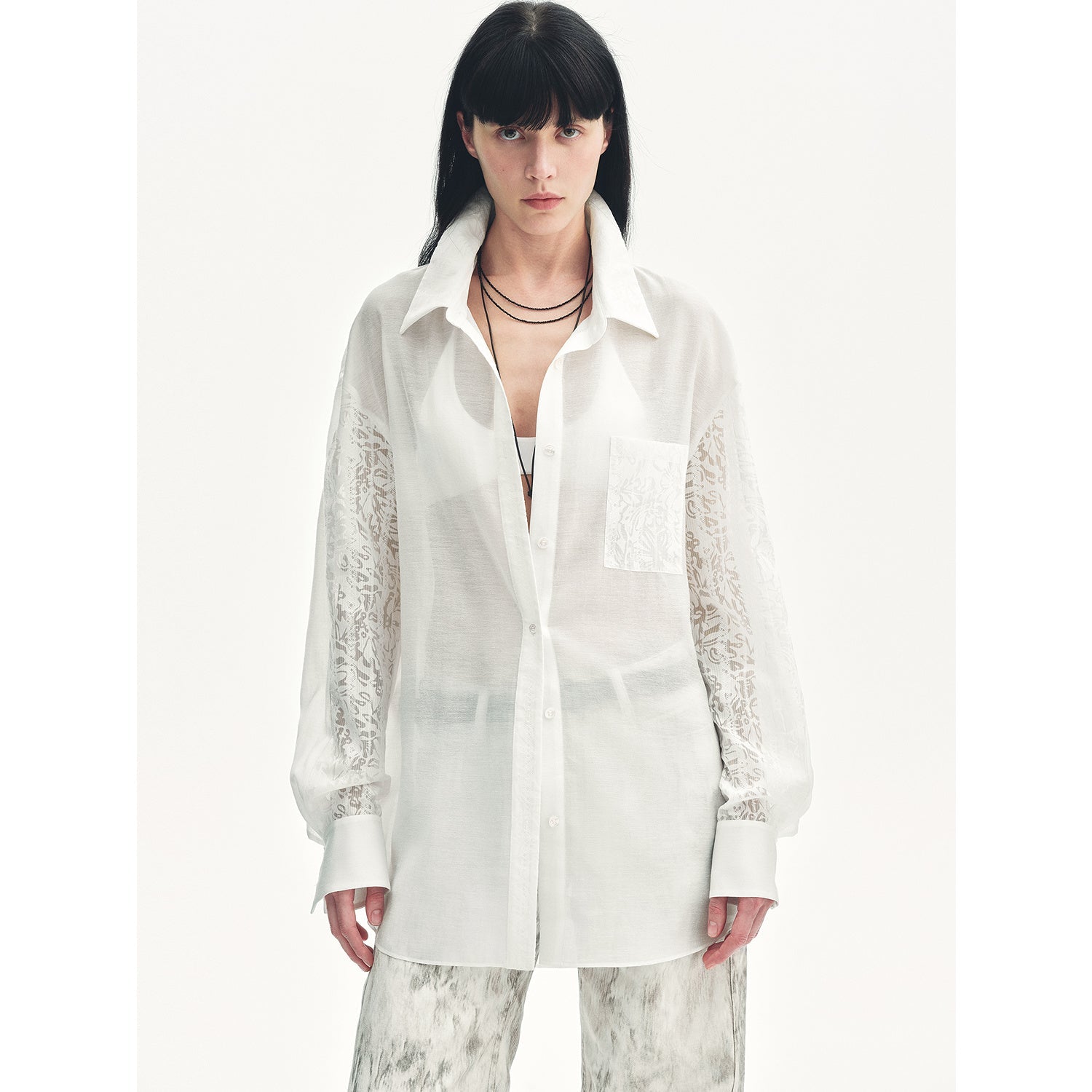 Woman wearing a white blouse with lace sleeves on a white background