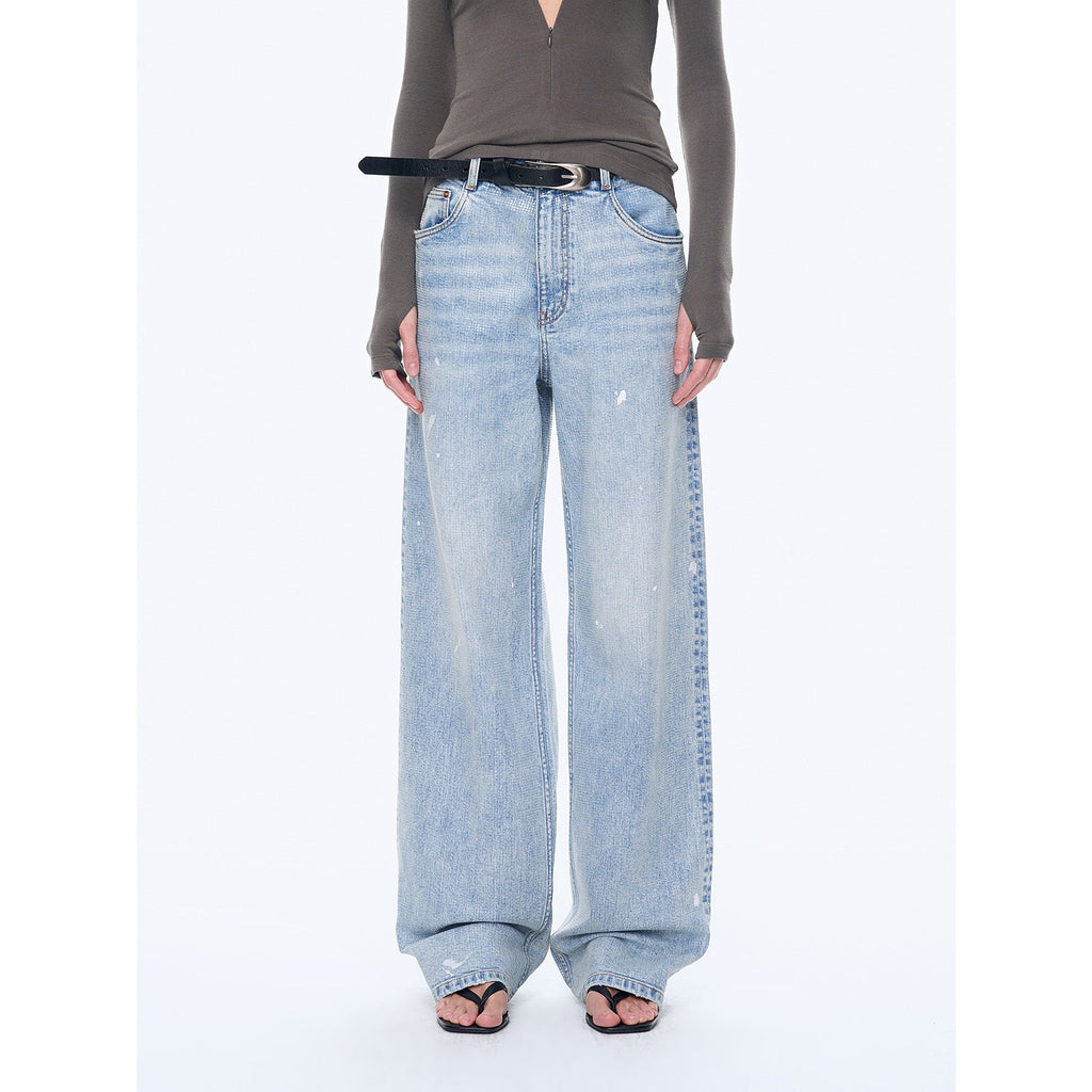 Person wearing light blue wide-leg jeans on a white background