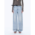 Person wearing light blue wide-leg jeans on a white background