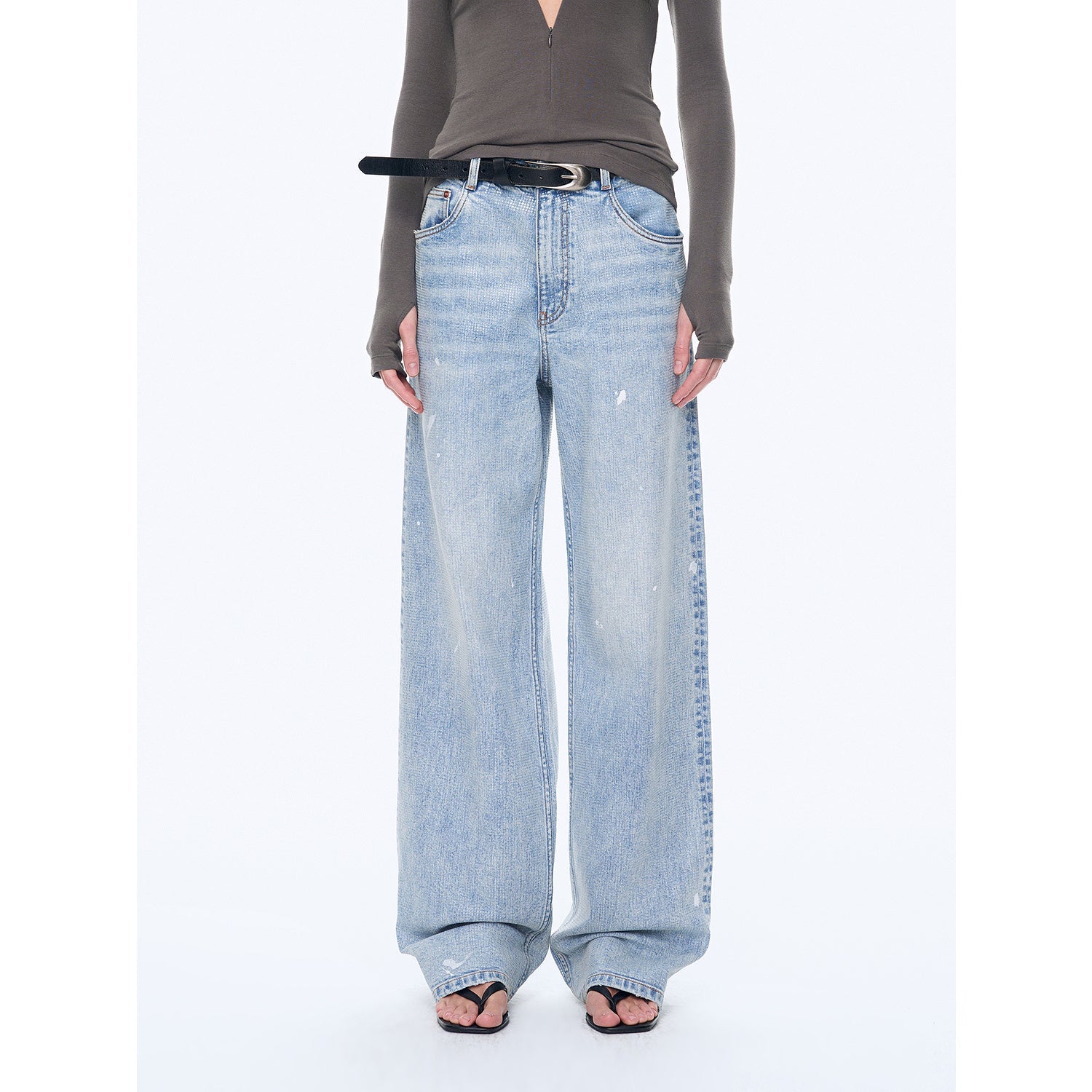 Person wearing light blue wide-leg jeans on a white background