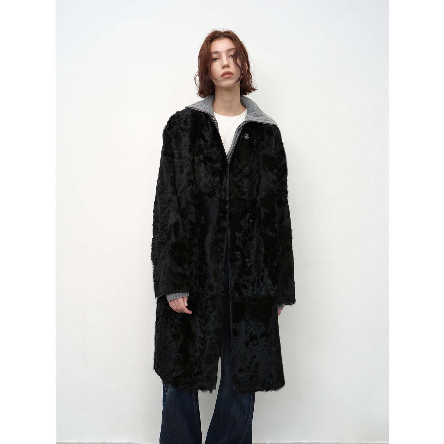 Person wearing a black fur coat on a white background