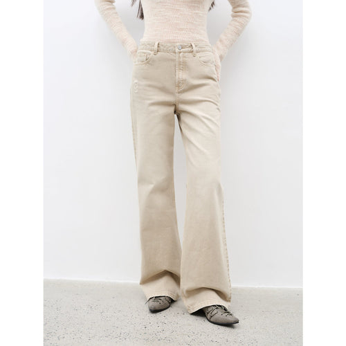 Person wearing beige flared pants on a white background